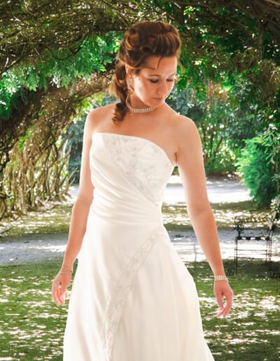 Bride Looking Downwards in Leafy Archway